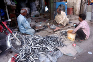 An artisan crafting Kulfi molds in his workplace at Shalini Chowk