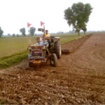 A farmer ploughing a farm field to prepare for new crop at Lahore Road