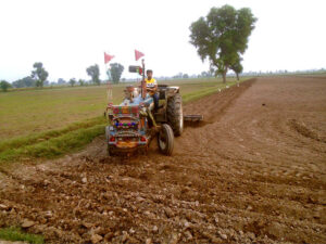 A farmer ploughing a farm field to prepare for new crop at Lahore Road