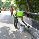 Workers painting the road side protector at zero point area