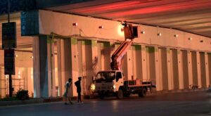 Workers busy in installing lights under bridge at Zero Point in Federal Capital.