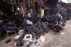 A vendor waits patiently for customers, selling and displaying a wide selection of imported vehicle accessories and spare parts at Shuba Bazaar, the city's largest hub for new and used auto parts.