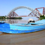 A view of boat parked in front of Lansdowne Bridge and Ayub Bridge at Left Bank of Indus River near Rohri