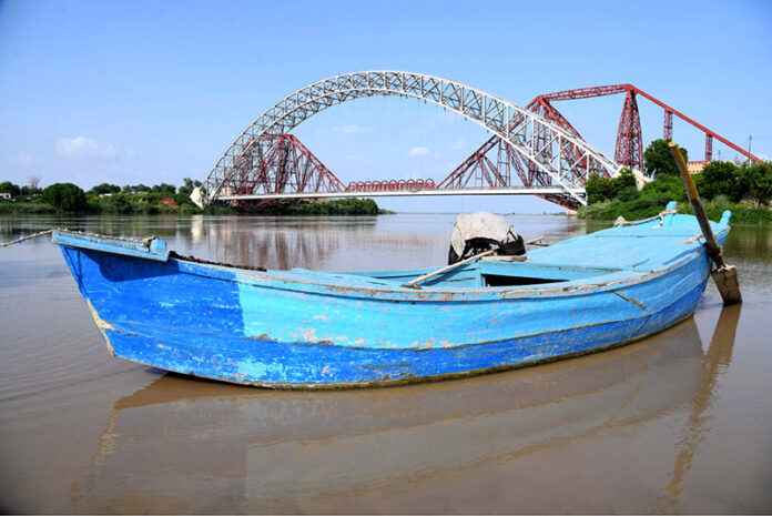 A view of boat parked in front of Lansdowne Bridge and Ayub Bridge at Left Bank of Indus River near Rohri