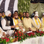 People participate in the Mehfil-e-Milad ceremony at Allama Iqbal Town