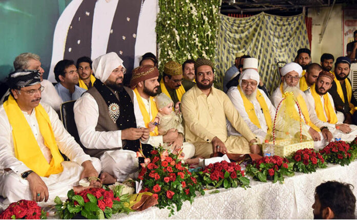 People participate in the Mehfil-e-Milad ceremony at Allama Iqbal Town