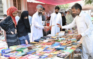 People busy in selecting and purchasing old books from roadside stall at Mall Road.