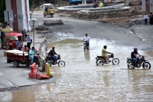 A motorcyclist wades through a flooded road, where heavy rains have left streets submerged in rainwater in the provincial capital.