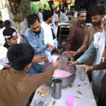 Volunteers serving drinks to the participants of the Eid Milad Un Nabi (PBUH) procession at G-7 area in the federal capital