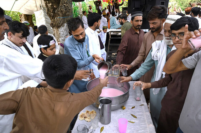 Volunteers serving drinks to the participants of the Eid Milad Un Nabi (PBUH) procession at G-7 area in the federal capital
