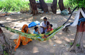 A gypsy mother gently swings her child in a makeshift hammock tied to a tree on the outskirts of Thandi Sarak.