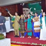 Students performing in tableau on stage during function on the occasion of Pakistan Defense Day at Shah Latif Girls College, Latifabad