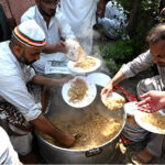 Volunteers serving free food to the participants of the Eid Milad Un Nabi (PBUH) procession at G-7 area in the federal capital