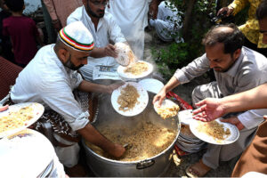 Volunteers serving free food to the participants of the Eid Milad Un Nabi (PBUH) procession at G-7 area in the federal capital