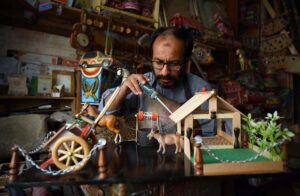 A craftsman is giving final touches to a handmade decoration item at his workplace near Dabgari area.