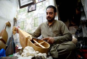 A man crafts traditional Rabab instruments at their workshop in the historic Dabgari area.