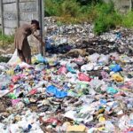 A gypsy boy searching valuables from garbage near Khanna Pul area in the Federal Capital