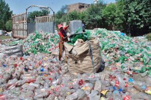 Laborer busy in collecting usable plastic bottles for recycling process at Northern bypass.