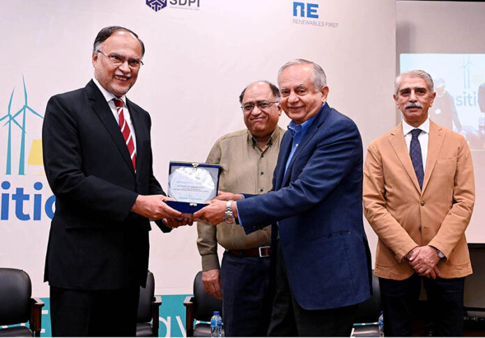 Abdul Razak Dawood presenting a shield to Federal Minister for Planning, Development & Special Initiatives, Ahsan Iqbal, during Asia’s Energy Transition Summit at LUMS University