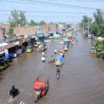 Vehicle passing through stagnant rain water accumulated at Nishatabad after heavy rain in the city