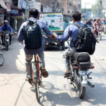 A cyclist student holding hand of a motorcyclist student help him to reach his destination