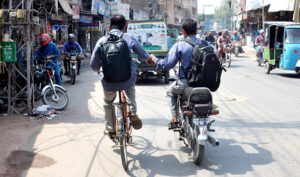 A cyclist student holding hand of a motorcyclist student help him to reach his destination