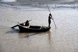 Fishermen on their way on boat rowing in the right bank of River Indus near Larkana-Khairpur Road