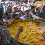 Volunteers serving free food during the religious procession of Eid Milad-un-Nabi celebrations in the city