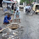 Municipal workers are busy cleaning the main hole near Railway Station