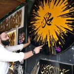 An artist creates beautiful calligraphy in a plastic signboard (Arashi Katbah) in preparation for Eid Milad-ul-Nabi (PBUH) celebrations at Samanabad LOS Road