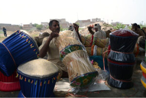 A laborer is busy putting the finishing touches on a murha (stool) made of wooden planks in a slum near the Ravi River.