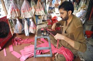 An elderly man meticulously crafts slingshots at his workshop for sale near Dabgari area.