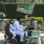A family on motorcycle attending the religious procession of Eid Milad-un-Nabi celebrations in the city