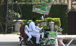 A family on motorcycle attending the religious procession of Eid Milad-un-Nabi celebrations in the city