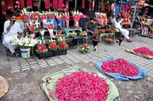 Vendors displaying and selling the flower bouquet and flowers garlands to attract the customers outside his shop in flower market.
