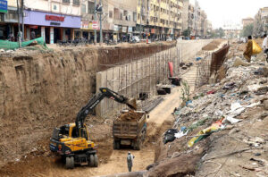 An underpass underway in the Kareemabad area near Meena Bazar Road during development work, as a crane visible at the construction site.