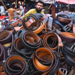 A vendor displaying and selling the leather belts on his handcart at Landa Bazar in the Provincial Capital