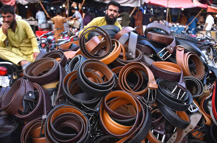 A vendor displaying and selling the leather belts on his handcart at Landa Bazar in the Provincial Capital