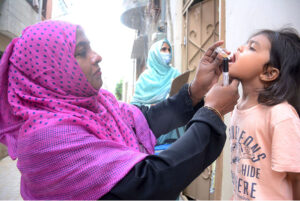 A lady health worker administering polio drops to children as part of seven days nationwide anti-polio campaign started from today