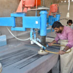 Labourers polishing marble slabs with machines at a marble industry