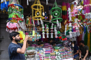 A shopkeeper is arranging decorations items for selling in connection with Eid Milad-un-Nabi (PBUH) at Gumpat Road