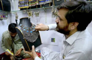 - A skilled worker making traditional Afghan jewelry at his workplace in Afghan Market.