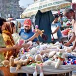 People selecting and purchasing second hand toys from roadside vendor in Provincial Capital