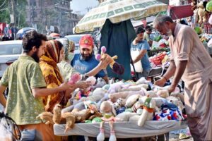 People selecting and purchasing second hand toys from roadside vendor in Provincial Capital