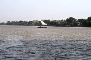 In the center of the Indus River, fishermen are catching fish on their boats in a traditional way.