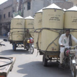 Tricycles loaded with large wheat storage boxes making its way to their destination in the city
