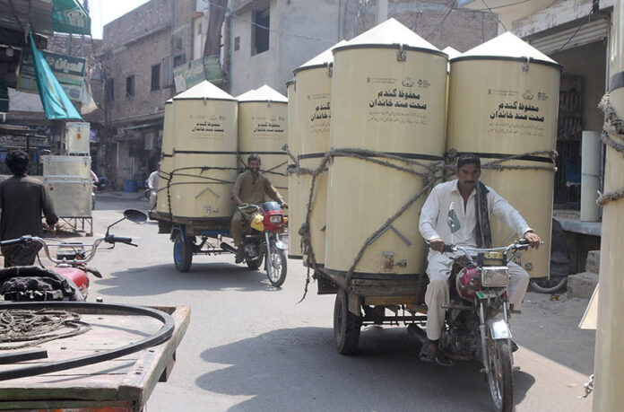 Tricycles loaded with large wheat storage boxes making its way to their destination in the city