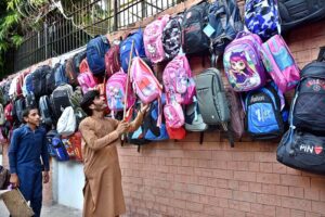 People selecting and purchasing second hand toys from roadside vendor in Provincial Capital