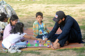 A man makes memories with his family, playing the traditional game of Ludo at Shalimar Bagh.