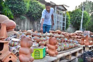 A pottery seller is attracting customers by installing home decor items made of clay near the Muslim Town market.